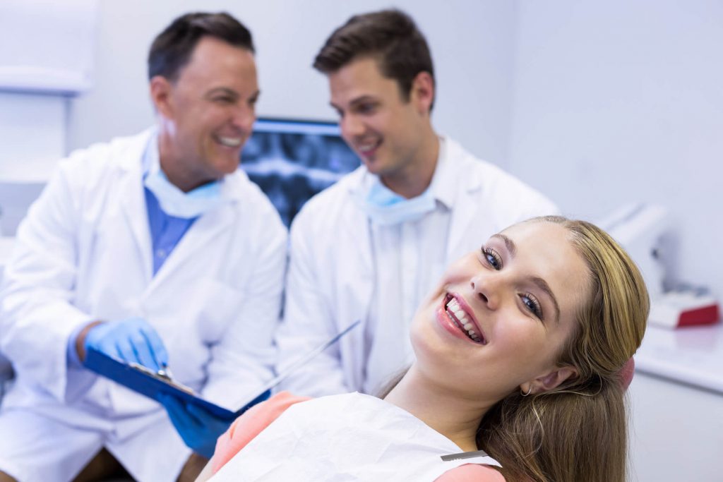 patient smiling with Oral Surgeon Davie in the background