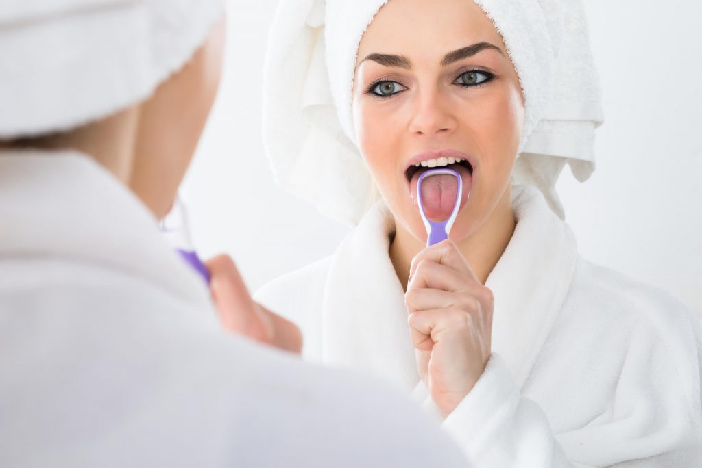 woman cleaning her mouth as advised by the best dentist in Weston