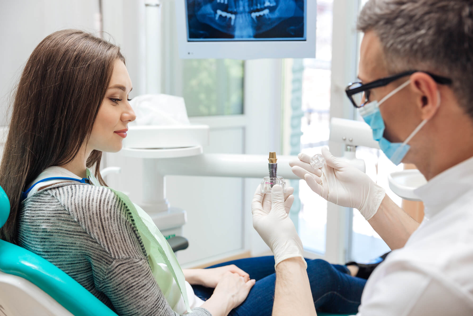dentist orients patient about dental implants in Davie