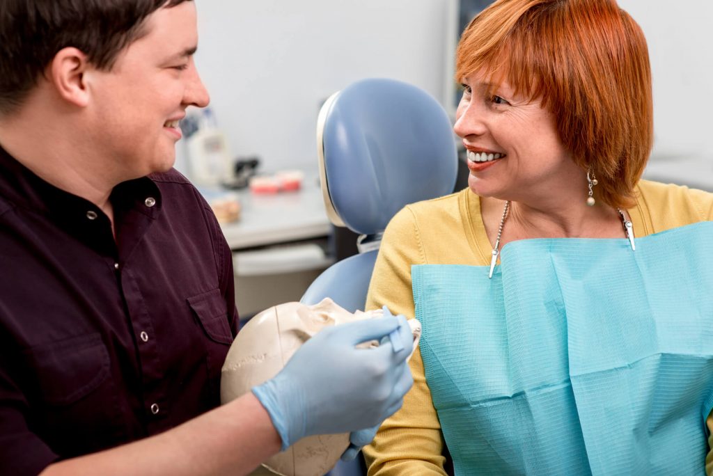 a dentist and an older female patient discussing Dental implants in Weston 